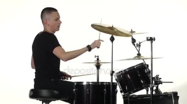 Profesyonel müzisyen müzik sopa yardımıyla davul çalıyor. Beyaz arka plan. Yan görünümü. Ağır çekim