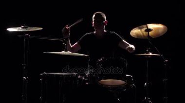 Müzisyen profesyonel olarak iyi müzik sopa kullanma davul çalıyor. Siyah arka plan. Siluet. Ağır çekim