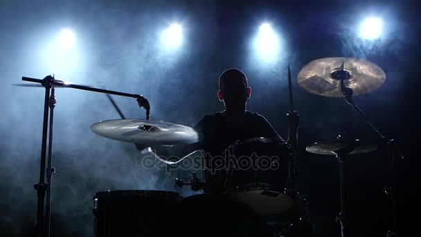 Energieke muziek bij de uitoefening van een professionele drummer. Zwarte rokerige achtergrond. Silhouet. Slow motion — Stockvideo