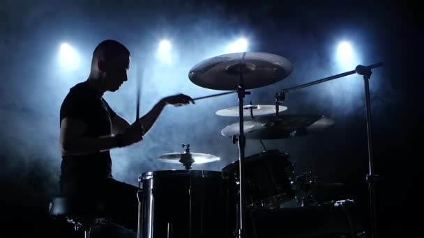 Musiker spielt eine Melodie auf dem Schlagzeug. schwarzer Rauchhintergrund. Seitenansicht. Silhouetten. Zeitlupe — Stockvideo