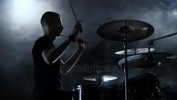 O baterista toca música enérgica no tambor. Fundo preto. Vista lateral. Movimento lento — Vídeo de Stock