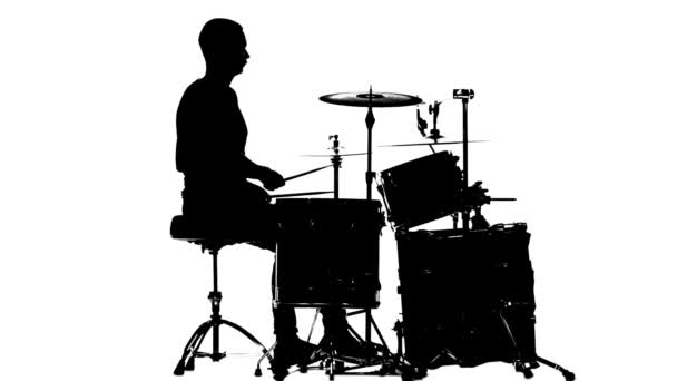 Guy plays the music on the drum. White background. Silhouettes. Side view. Slow motion — Stock Video