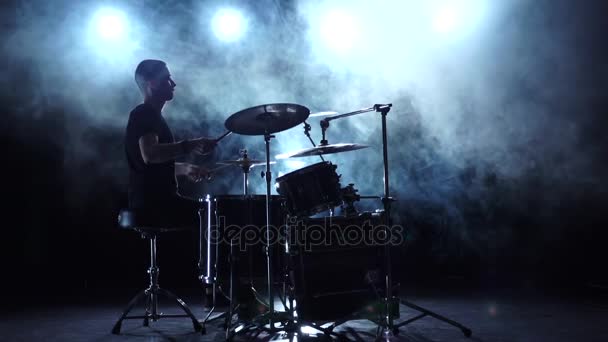 Muzikant speelt professioneel goede muziek op drums met behulp van stokken. Rokerige achtergrond. Silhouet. Slow motion — Stockvideo