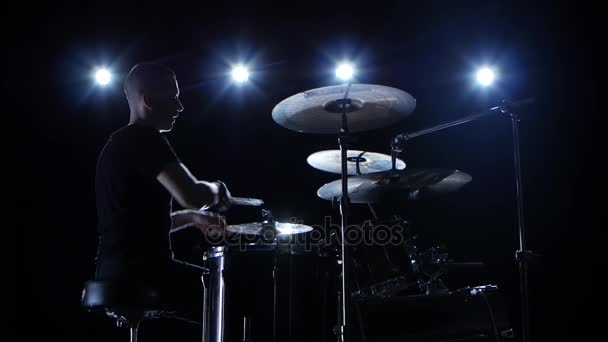 Musicista suona professionalmente musica alla batteria. Fondo nero. Vista laterale. Retroilluminazione. Silhouette — Video Stock