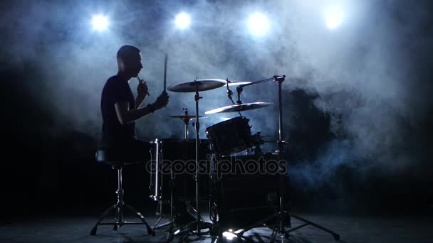 Energetische muzikant speelt goede muziek op drums. Zwarte rokerige achtergrond. Silhouet — Stockvideo