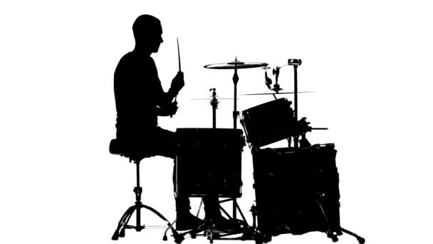 Guy plays the music on the drum. White background. Silhouettes. Side view