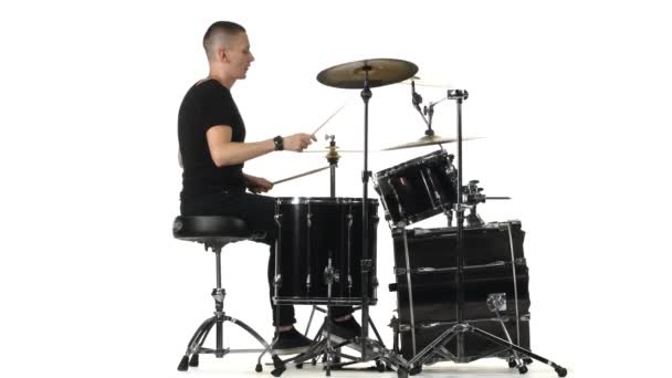 Músico profesional toca música en la batería con la ayuda de palos. Fondo blanco. Vista lateral — Vídeos de Stock
