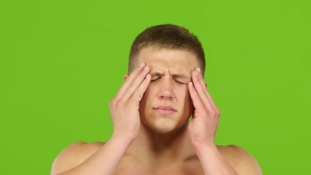 Мужчина с головной болью массаж висков рук, зеленый экран. Крупный план — стоковое видео