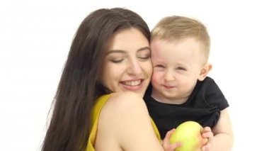 Anne bebeğini, gülüyor öper. Beyaz arka plan. Ağır çekim