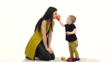 Anne ve çocuk sebze kolaçan. Beyaz arka plan. Ağır çekim