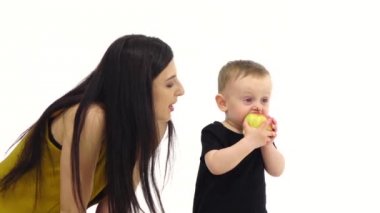 Bebek bir elma yiyor, beğendi. Beyaz arka plan. Ağır çekim