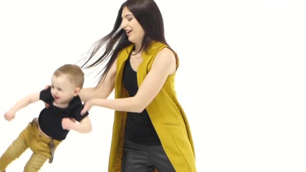 Moeder van haar baby omhoog gooit, houdt hij het lacht. Witte achtergrond. Slow motion — Stockvideo