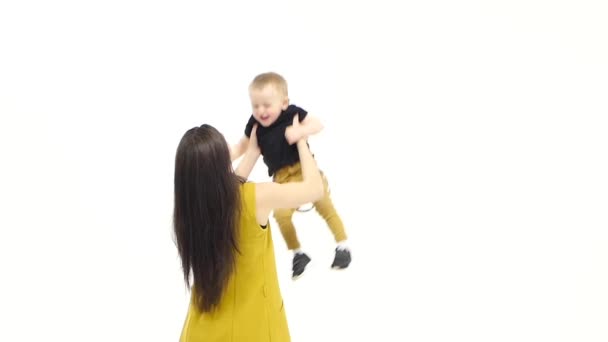 La fille tourne autour de son fils, il rit. Fond blanc. Mouvement lent — Video