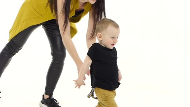 Kind tritt in einem geräumigen Raum auf den Boden. weißer Hintergrund. Zeitlupe — Stockvideo