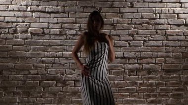 Kadın yüksek topuklarla esnek dans twerk bir tuğla duvara