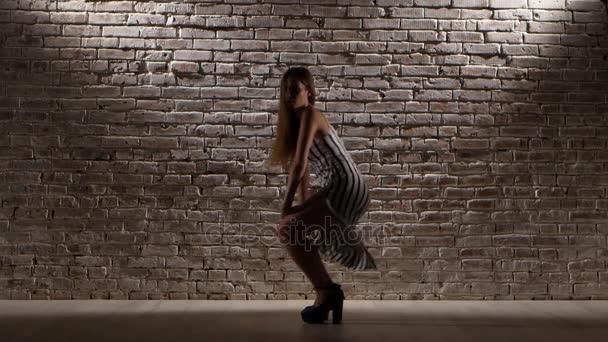Frau tanzt graziös in High Heels gegen eine Ziegelwand — Stockvideo