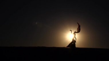 Dansçı vücudu ile cinsel hareketler yapar. Siluet. Ağır çekim