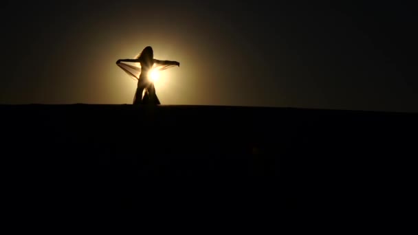 Dziewczyna wykonuje piękny taniec brzucha na tle zachodu słońca. Sylwetka. Zwolnionym tempie — Wideo stockowe
