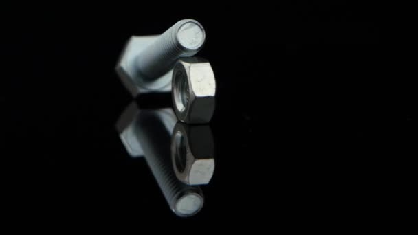 Porca e parafuso girar em suporte de vidro preto em close-up — Vídeo de Stock