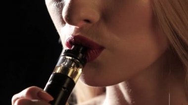 Kız mendil içiyor, kırmızı ruj dudakları var. Siyah arka plan