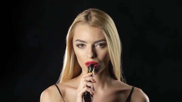 Blonde smokes an electronic cigarette and the smoke disperse. Black background — Stock Video