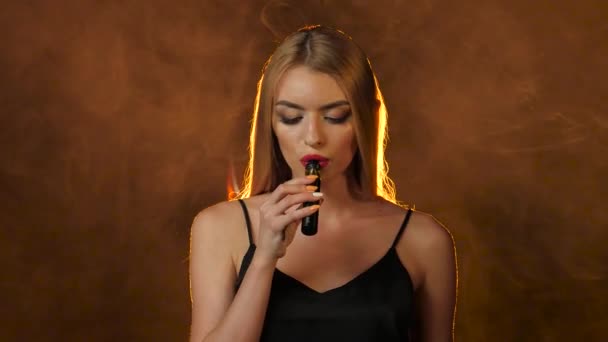 Blondýnka kouří elektronické cigarety, ona je sexy. Zlaté kouřové pozadí — Stock video