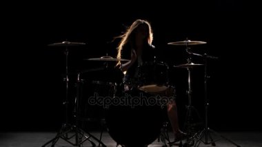 Enerjik müzik davul, oynamaya başladı kızdır. Siyah arka plan. Siluet