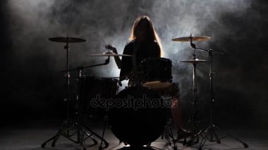 Özel eğitimli kız bateri çalıyor. Siyah duman arka plan. Siluet