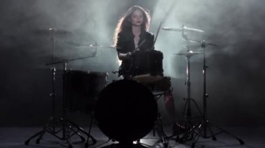 Kız krep yerken üzerine pound için seviyor davul çalıyor. Siyah duman arka plan. Ağır çekim