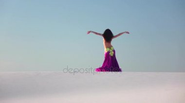 Zarif dansçı karşı parlak bir kıyafetle oryantal dans gökyüzü. Ağır çekim