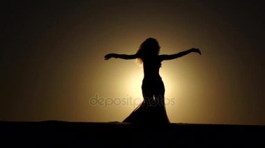 Ona esmer peçe dans oryantal dans sahilde eller. Siluet. Ağır çekim