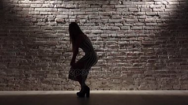 Topuklar hafif tuğla duvara twerk dans seksi kız. Siluet. Ağır çekim