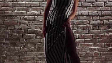 Topuklu enerjik kadın dans bir tuğla duvara twerk. Ağır çekim. Yakın çekim