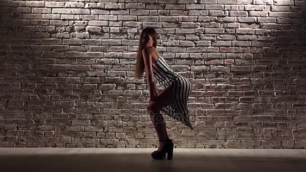 Frau anmutig in High Heels tanzt twerk gegen eine Ziegelwand. Zeitlupe — Stockvideo