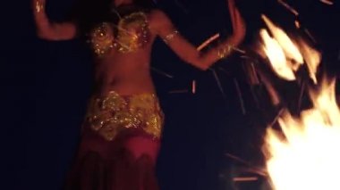 Özel giysili dansçı oryantal dans, ateşin yanında dans ediyor