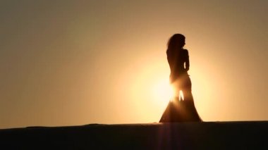 Sıcak bir gün batımı çerçevede incelikle dans dansçı. Siluet