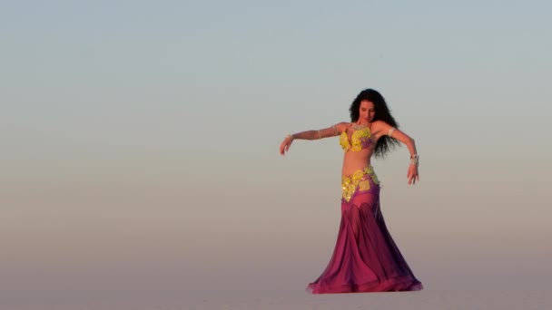 Brunette danse ventre dansant dans le désert de sable, ses mouvements sont uniques — Video