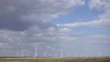 Arka plan mavi gökyüzünün ve yeşil ağaçlar üzerinde alanları esintiyle Pinwheels spin