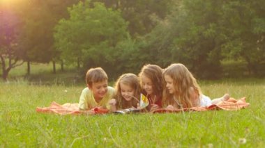 Çok güzel çocuklar birlikte bir çim üzerine bir kitap okuma yaz güzel öğleden sonra