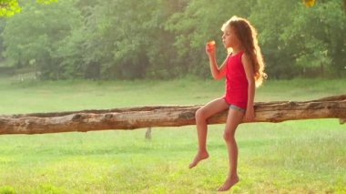 Mutlu kız parkta sabun köpüğü üfleme. Ağır çekim