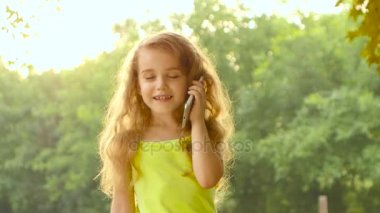 Smartphone güzel arka plan ağaçlar yaz gününde konuşan uzun saçlı kız. Yakın çekim