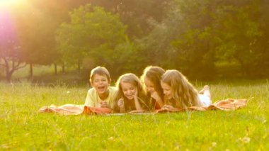 Mutlu çocuk bahçesinde bir kitap yaz günde çimenlikte aracılığıyla yaprak