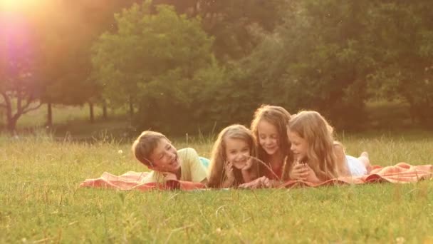 Dítě si prolistujte knihu v zahradě na trávníku, v létě denně — Stock video