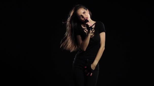Chica baila y canta en un concierto de rock, su cuerpo es sexy. Fondo negro. Movimiento lento — Vídeos de Stock