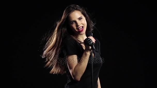 Ragazza balla e canta ad un concerto rock, il suo corpo è sexy. Fondo nero. Rallentatore — Video Stock