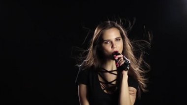 Onu konserde şarkıcı sürüş şarkıları ve enerjik dansları gerçekleştirir. Siyah arka plan. Ağır çekim