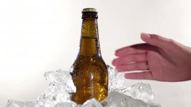 Adam bir şişe soğuk bira alır. Beyaz arka plan. Yakın çekim. Ağır çekim