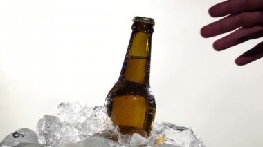 Adam bir şişe soğuk bira alır. Beyaz arka plan. Yakın çekim. Ağır çekim