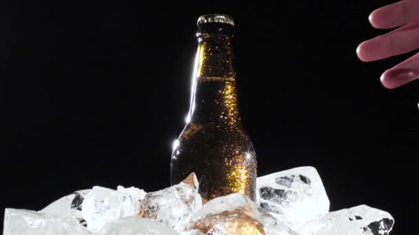 Festival, un homme sort une bouteille de bière avec de la glace. Fond noir. Ferme là. Mouvement lent 