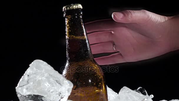 Man takes a bottle of cold beer. Black background . Close up. Slow motion — Stock Video